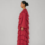 Woman wearing a red layered dress against a gray background