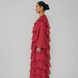 Woman wearing a red layered dress against a gray background