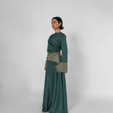 Woman wearing a green dress with patterned accents on a white background