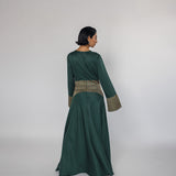 Woman wearing a green dress with a textured top on a white background