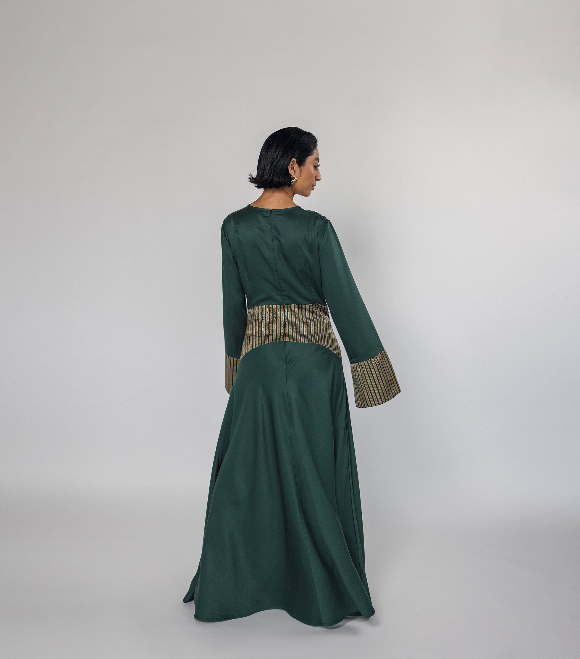 Woman wearing a green dress with a textured top on a white background
