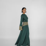 Woman wearing a green dress with a patterned belt on a white background