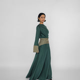 Woman wearing a green dress with a patterned belt on a white background
