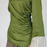 Green long-sleeve top with a ruched design on a plain background