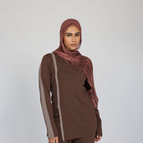 Model styled a brown outfit with a red clay ripple print hijab on a white background