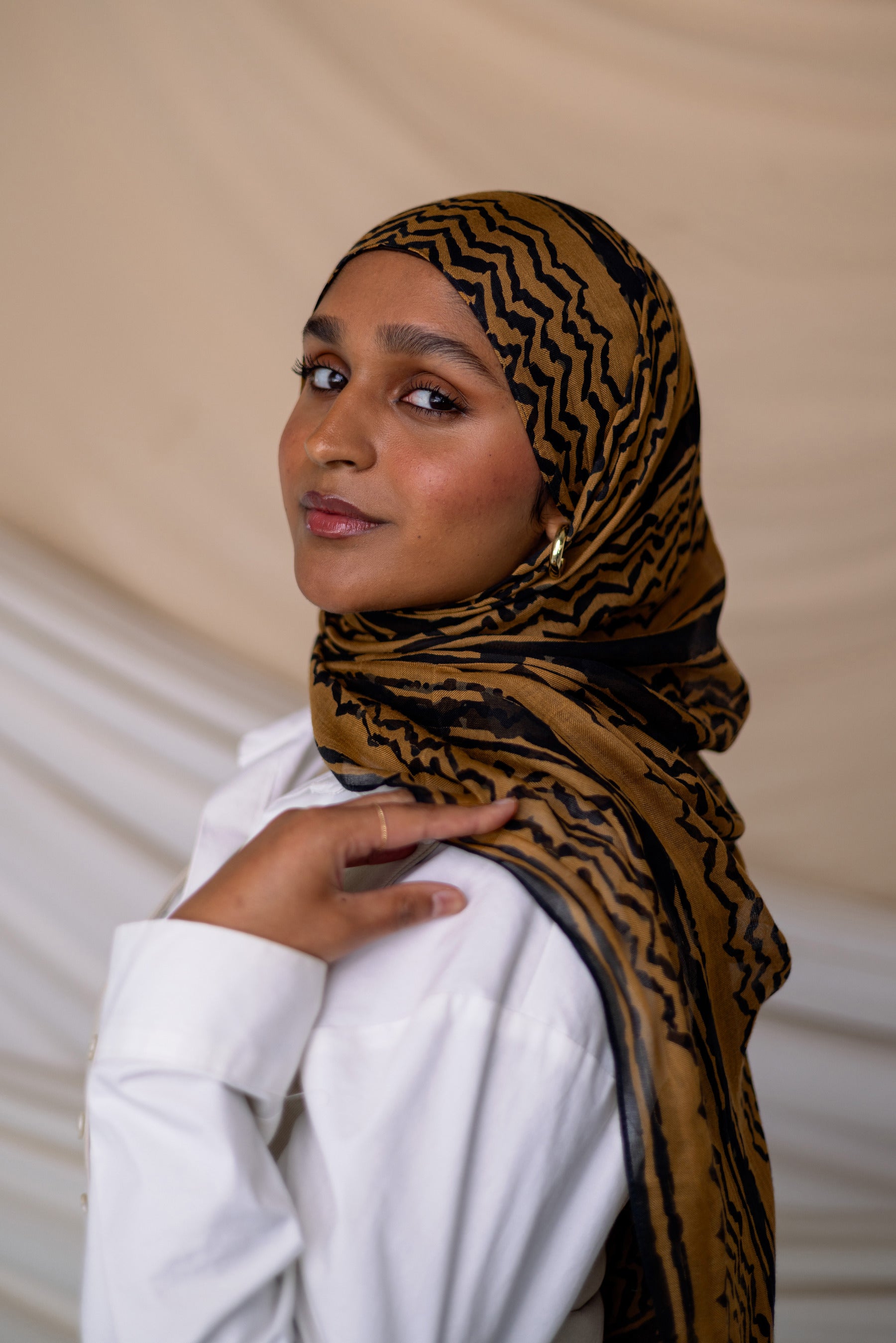 Model wearing VELA hijab designed with ancient motifs in a fresh, artistic execution.

