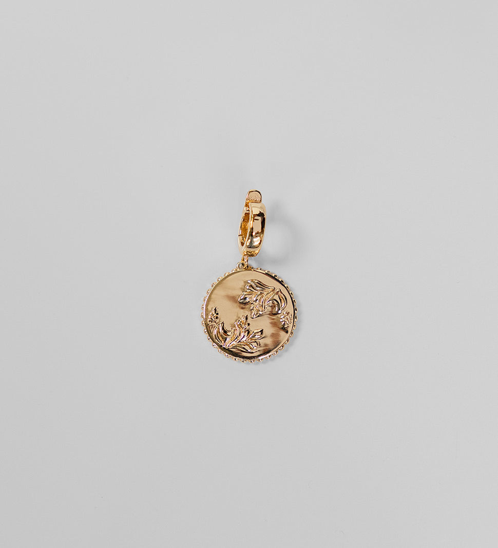 Gold Henna Charm on a light gray background