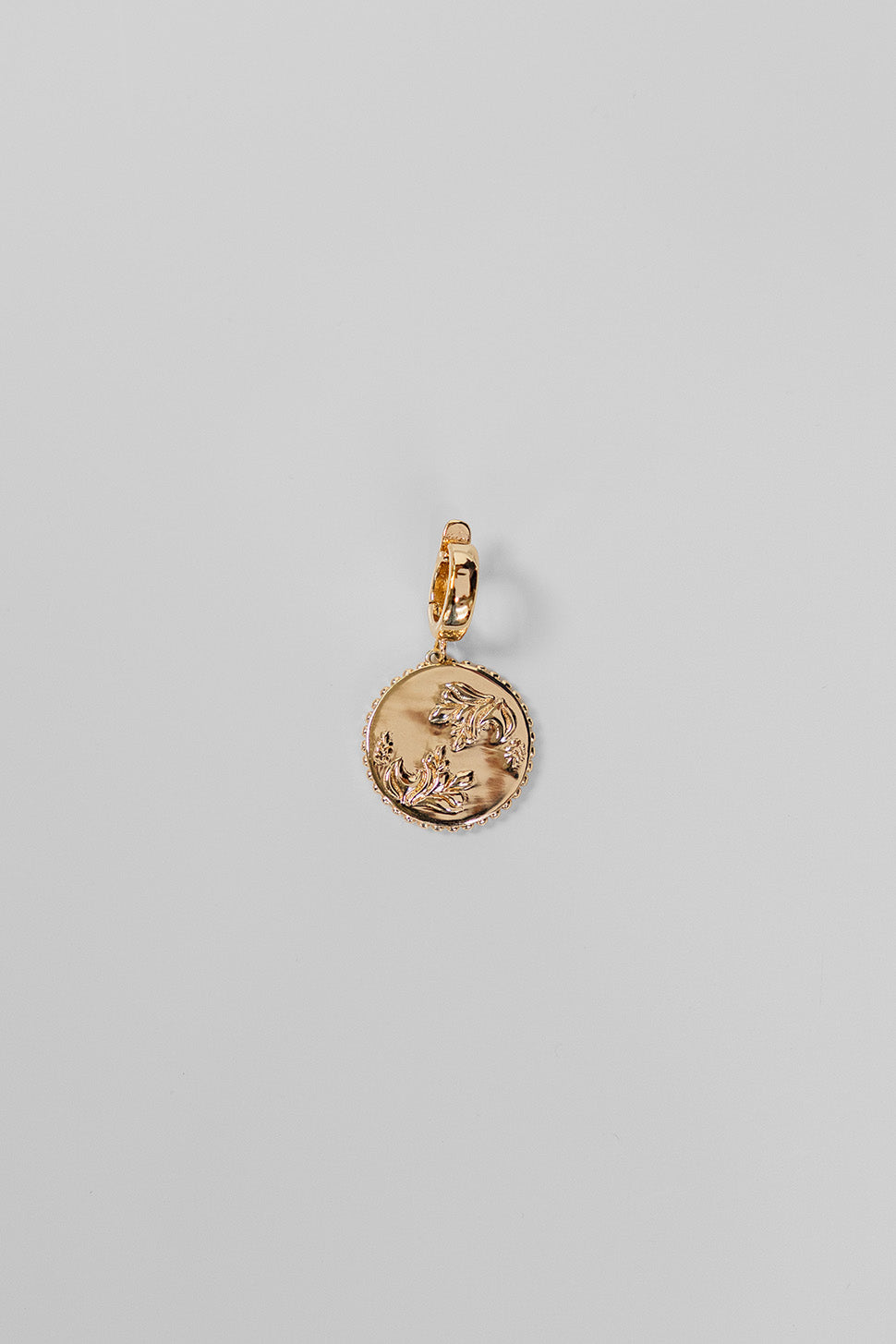 Gold Henna Charm on a light gray background