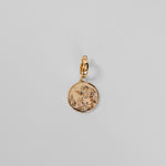 Gold Henna Charm on a light gray background