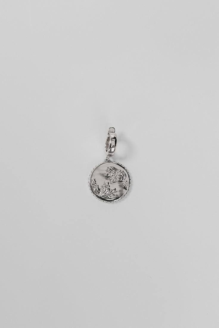 Silver Henna Charm on a light gray background