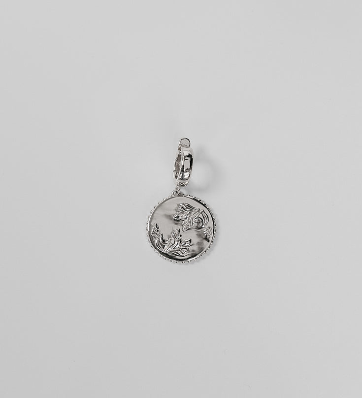 Silver Henna Charm on a light gray background