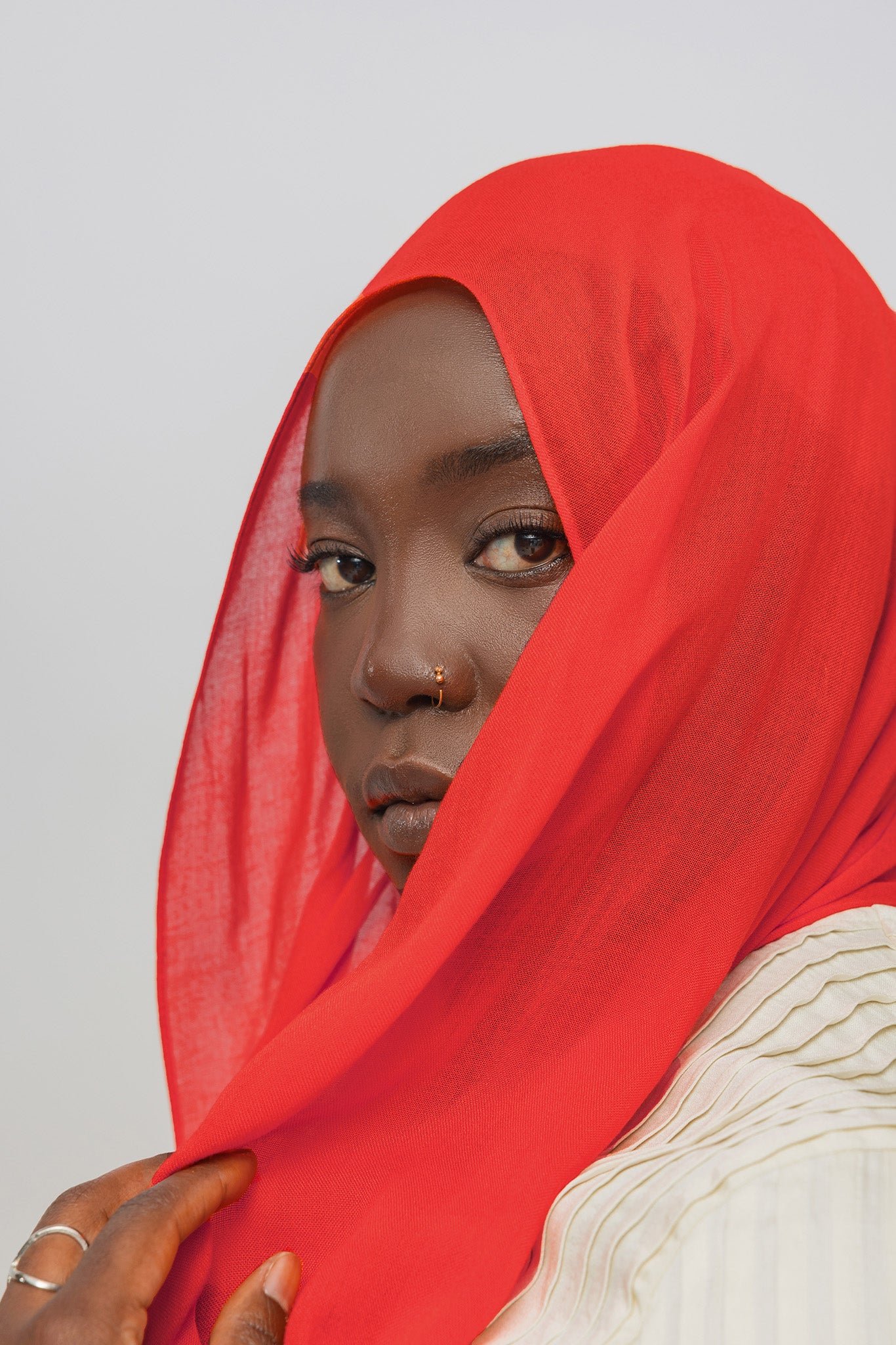 Person wearing a red hijab against a plain background