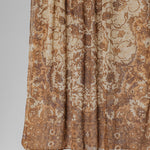 Brown and beige patterned hijab fabric on a plain background