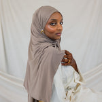 Model wearing Truffle Mink Jersey Lite, showing its lightweight, wrinkle-resistant drape in a classic wrap style.