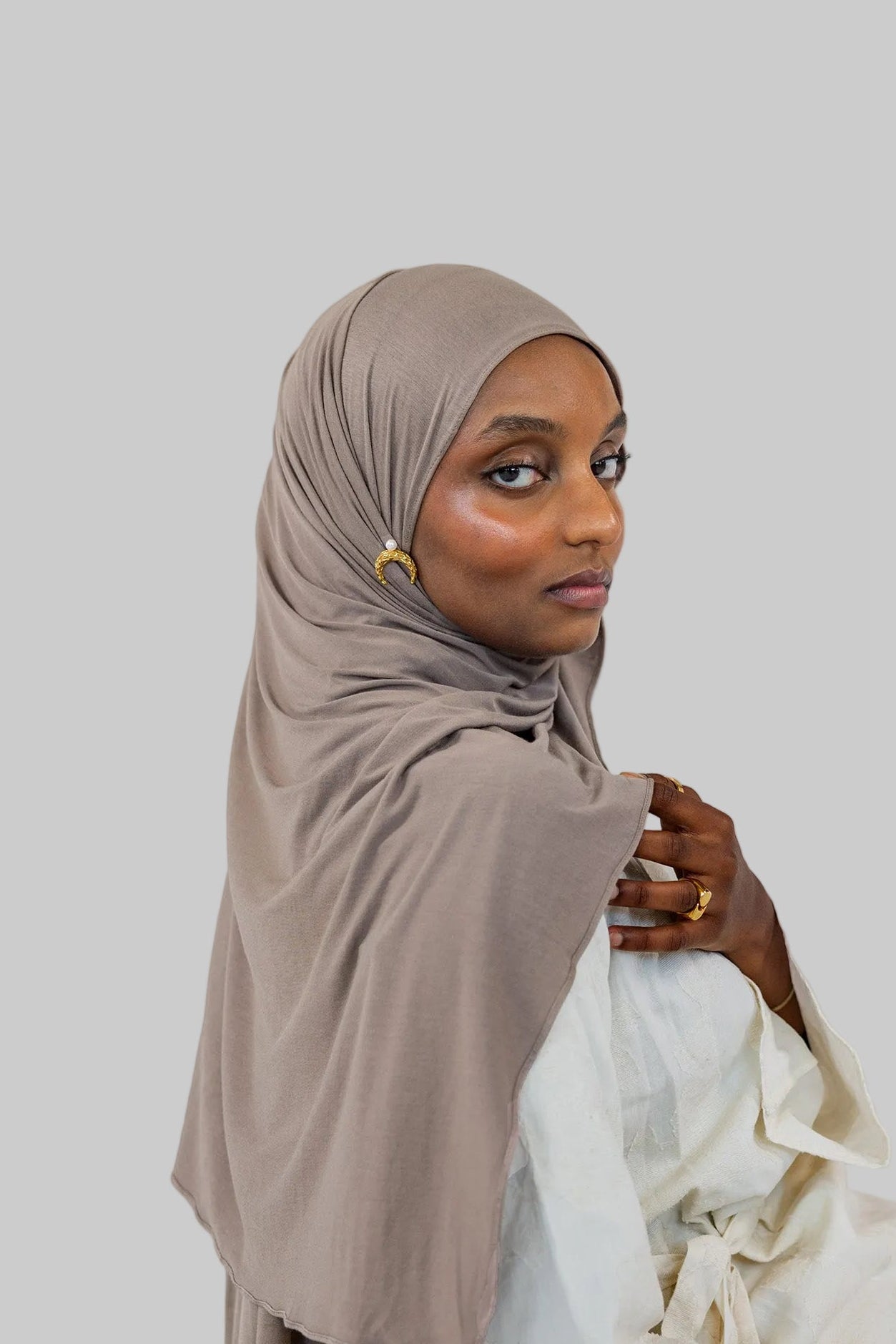 Model wearing Truffle Mink Jersey Lite, showing its lightweight, wrinkle-resistant drape in a classic wrap style.