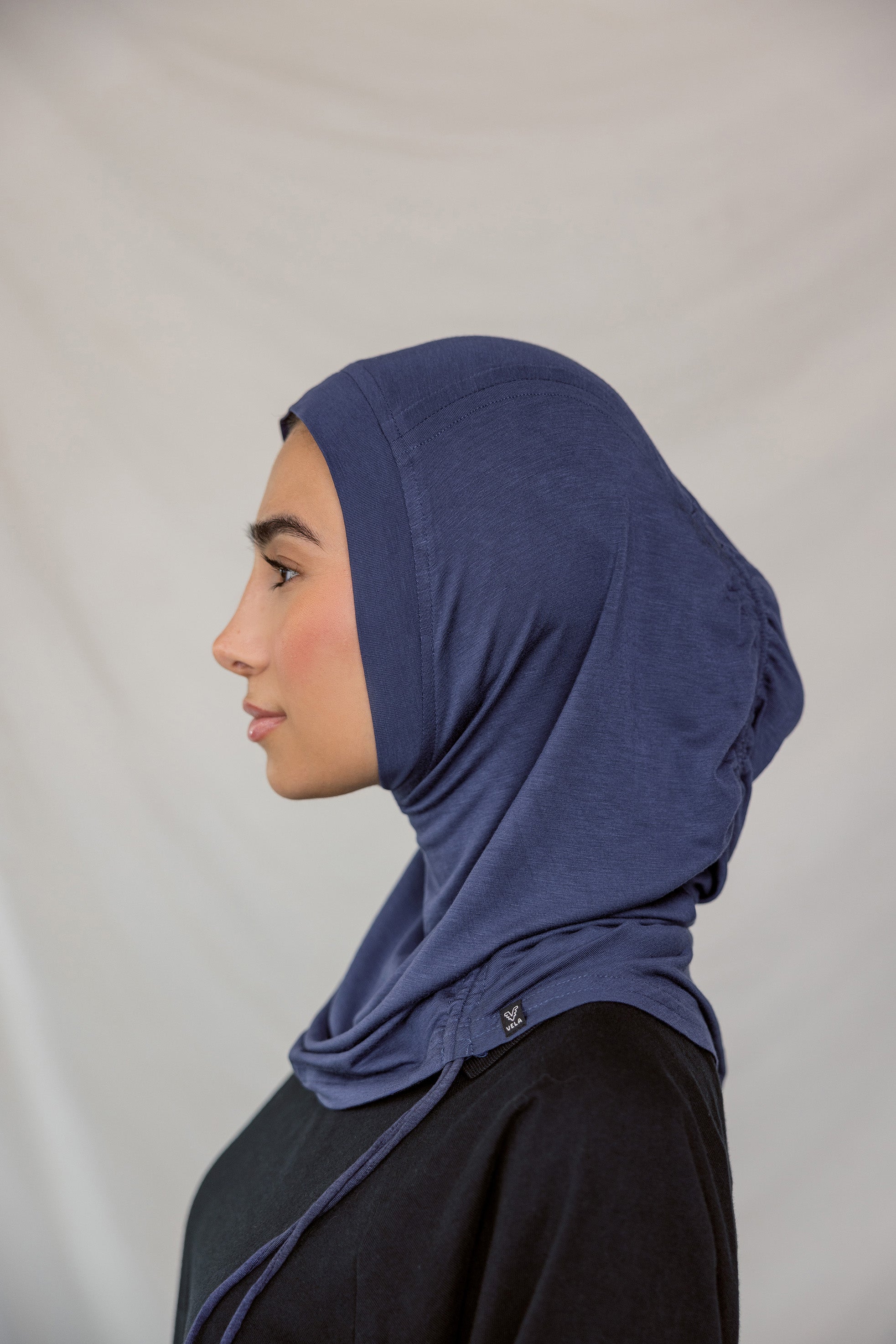 Model wearing Twilight Blue Ruching Lite, showing soft ruching near the frame of the face.