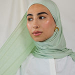 Model wearing Sage Mist Jersey Lite with a soft drape around the shoulders, highlighting its lightweight, wrinkle-resistant finish.