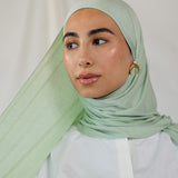 Model wearing Sage Mist Jersey Lite with a soft drape around the shoulders, highlighting its lightweight, wrinkle-resistant finish.