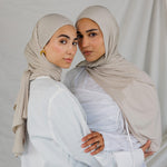  Two models wearing Ashwood Jersey Lite, highlighting its warm beige tone in different wrap styles.