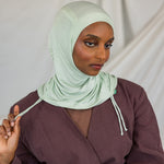 Model wearing Sage Mist Ruching Lite with light ruching around the face, emphasizing airy drape.