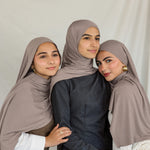 Three models stand together wearing Truffle Mink Jersey Lite, a universal taupe shade.
