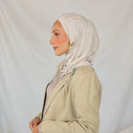 Model wearing Ashwood Ruching Lite fabric draped against white backdrop, revealing beige-ash tone and ruched design.