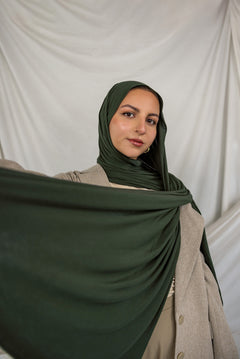 Model wearing Hunter Green Jersey Lite styled in a loose wrap, showcasing its breathable, wrinkle-resistant drape.