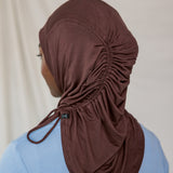 Model wearing a brown coffee hijab with a blue shirt against a beige background to show ruching back detail.