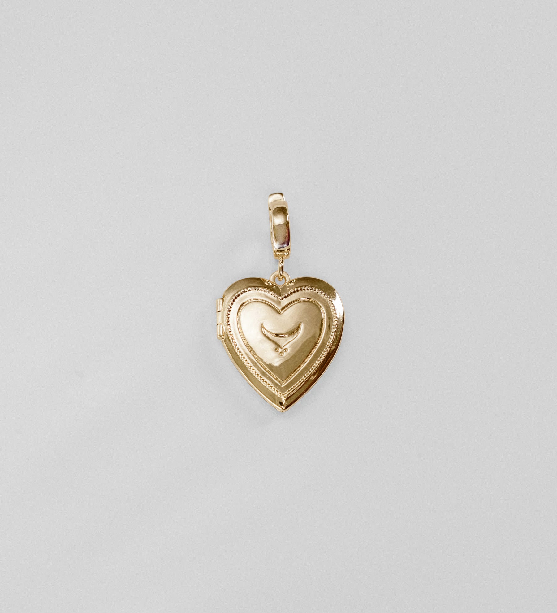Gold heart-shaped pendant on a light gray background