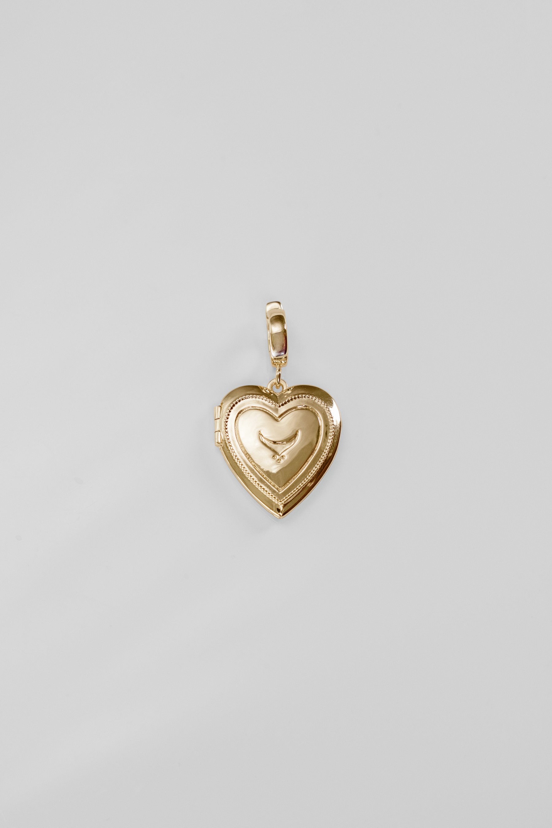 Gold heart-shaped pendant on a light gray background