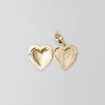 Gold heart-shaped locket on a light gray background