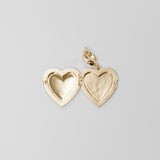 Gold heart-shaped locket on a light gray background