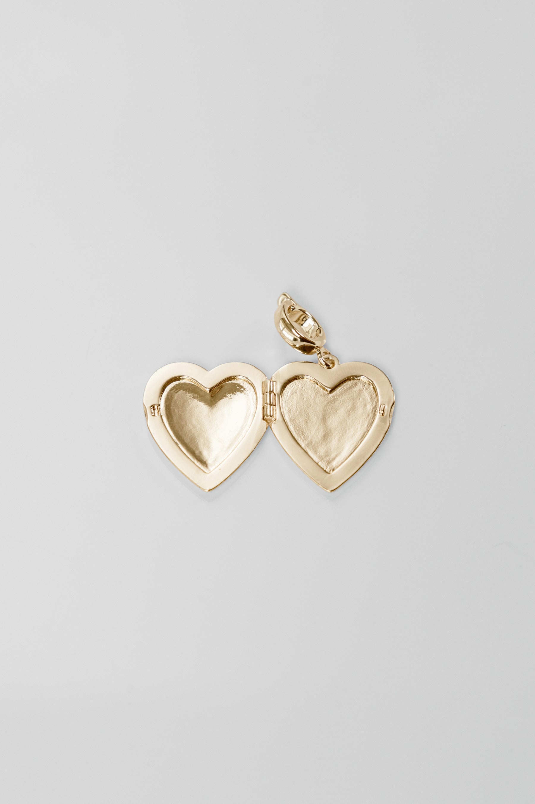 Gold heart-shaped locket on a light gray background