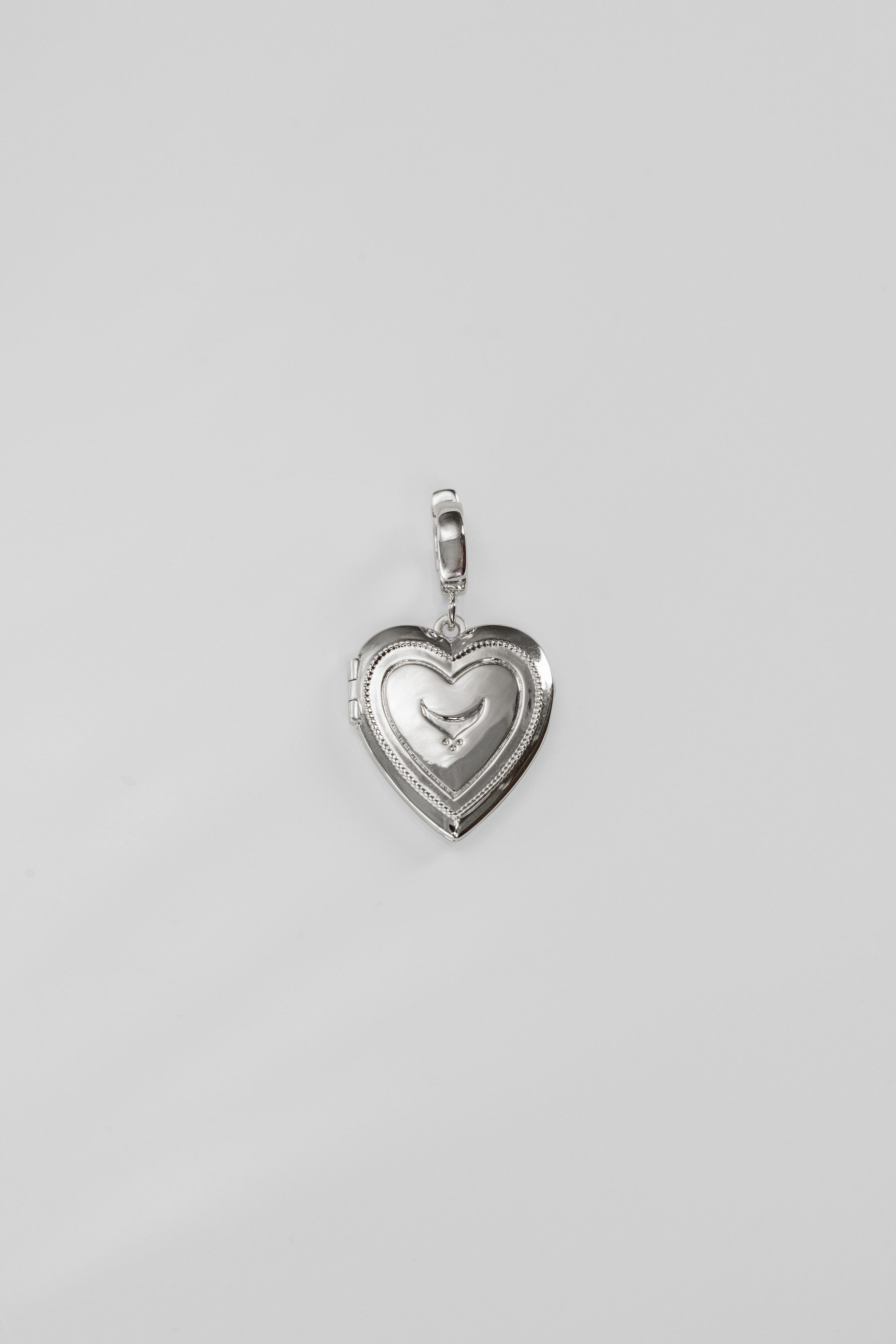 Silver heart-shaped pendant on a light gray background