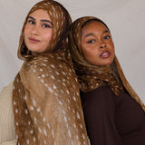 Two models shown, both wearing Fawn from VELA, a warm brown transitional print with white speckles. 