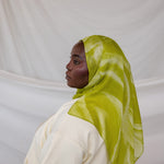 Person wearing a lime green sediment printed hijab against a white background