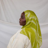 Person wearing a lime green sediment printed hijab against a white background