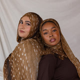 Two models shown wearing VELA's Fawn print, a warm brown-toned print with white speckles like a deer. 