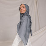 Model wearing the hijab, showing how the dark sage fabric wraps smoothly around the head and neck.