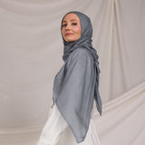 Model wearing the hijab, showing how the dark sage fabric wraps smoothly around the head and neck.