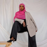 Model shown styled in Rose Wave, a vibrant pink solid scarf. 
