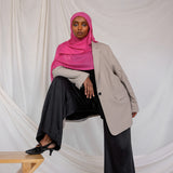 Model shown styled in Rose Wave, a vibrant pink solid scarf. 