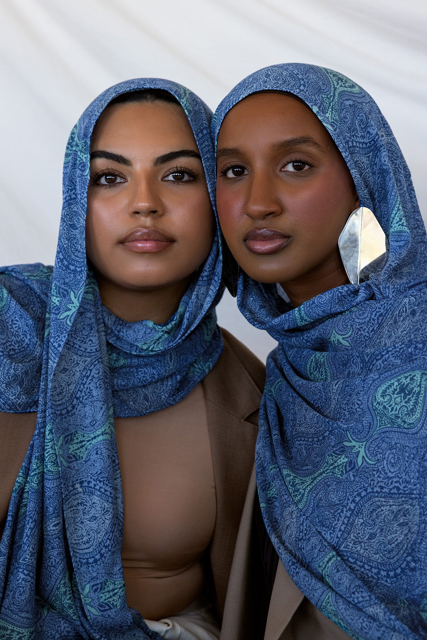Two models styled in a blue toned paisley print hijab. 