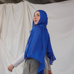 Spirulina Blue scarf pictured on model, this scarf by VELA is bright electric blue. 