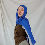 Model shown posing in Spirulina Blue, a vivid, electric Blue scarf by VELA. 