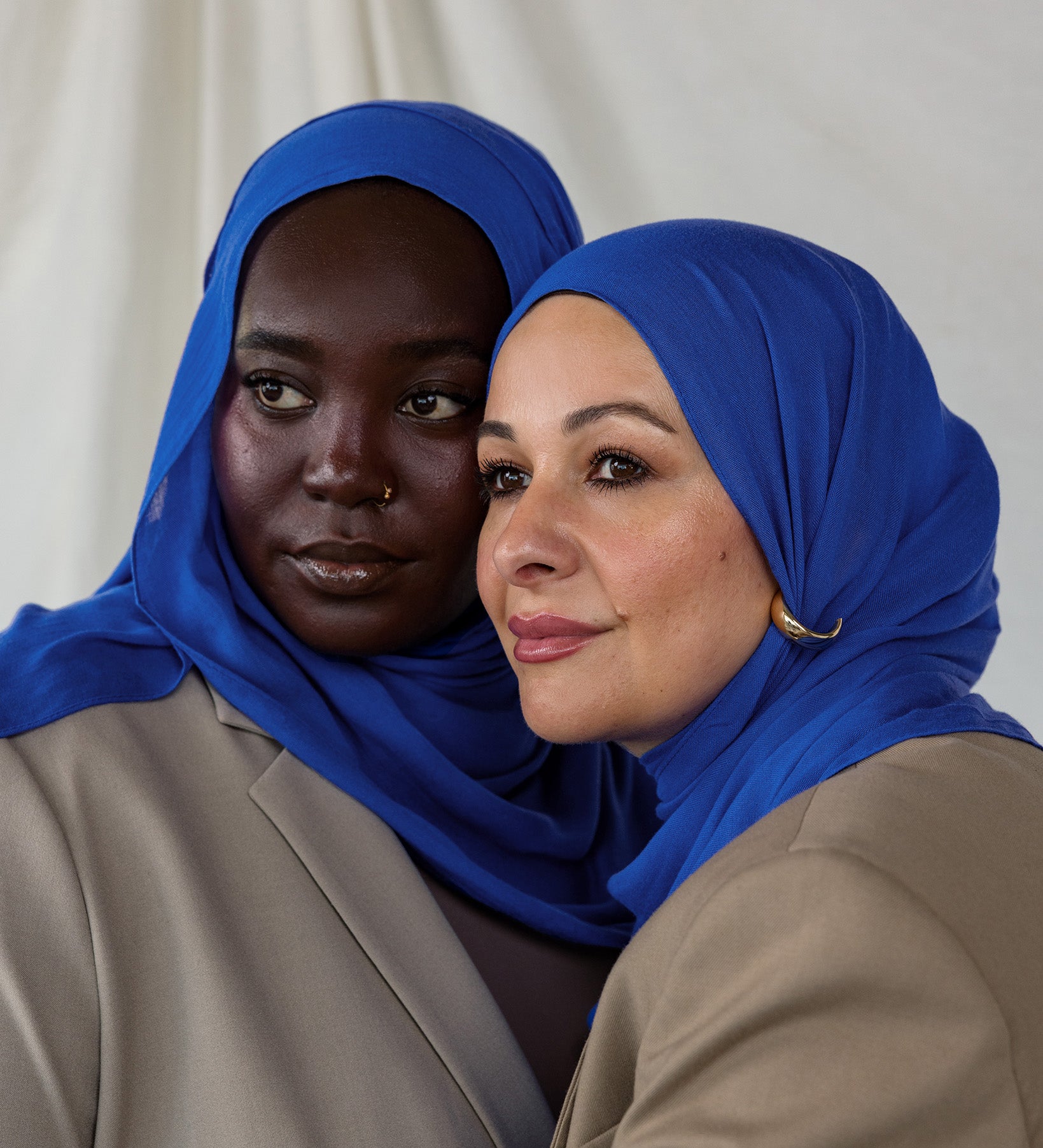 Close-up of Spirulina Blue on two models that shows the tone of the scarf - a vivid and saturated electric blue. 