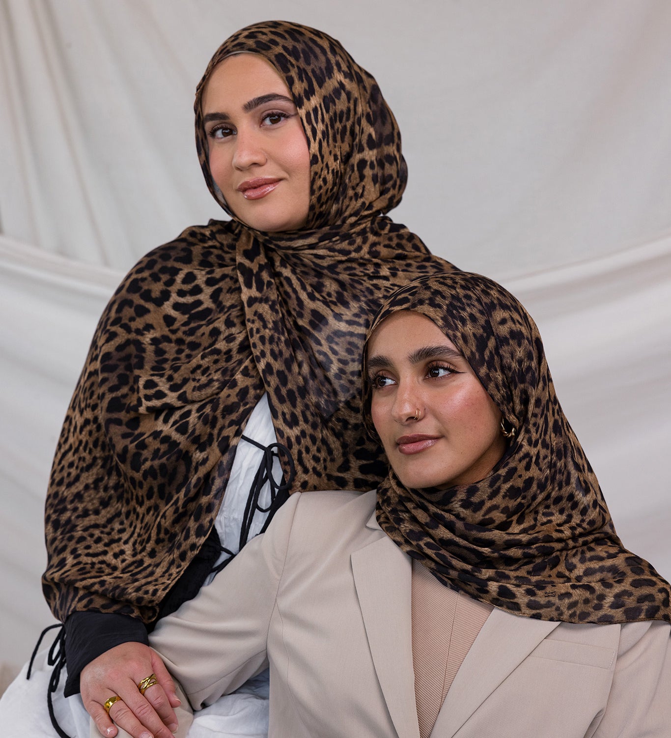 Two models wearing leopard print hijab on modal fabric.