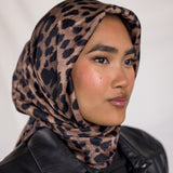 A woman wearing a leopard printed silk hijab. 