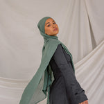 Model wearing a Pine Green hijab and dark clothing against a plain background