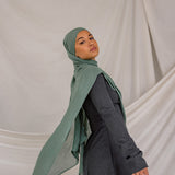 Model wearing a Pine Green hijab and dark clothing against a plain background